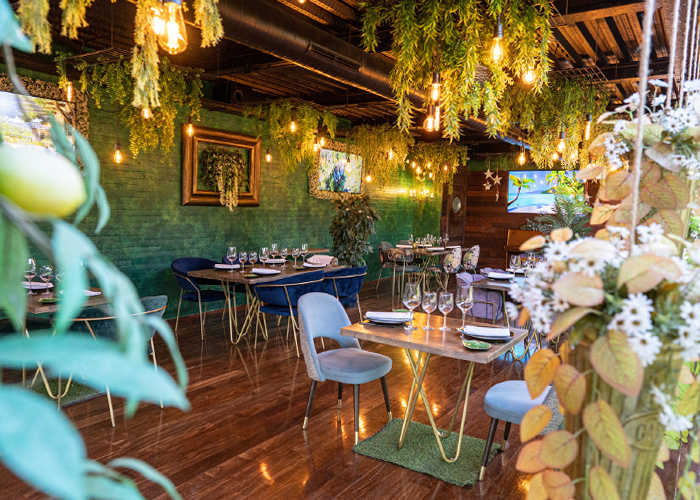 Comedor interior con cuadros y vegetación colgante