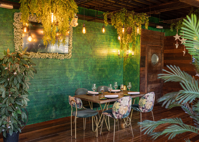 Mesa íntima frente a la pared verde del salón interior